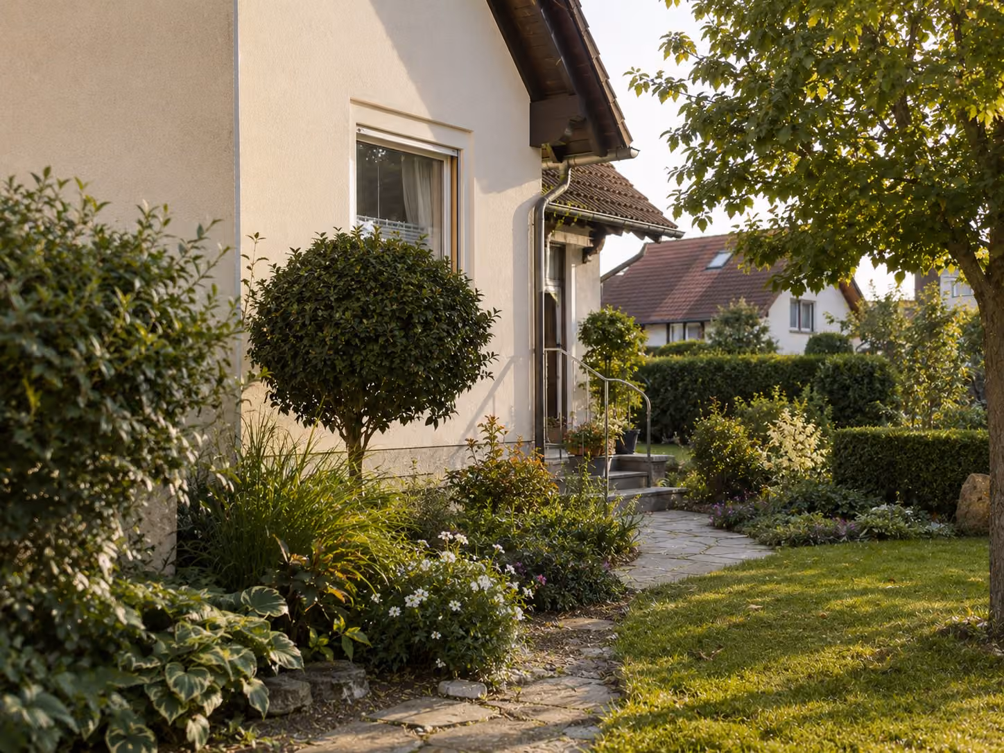 Wohnhaus mit Garten, Zugang über einen Steinweg, Nachbarhäuser im Hintergrund